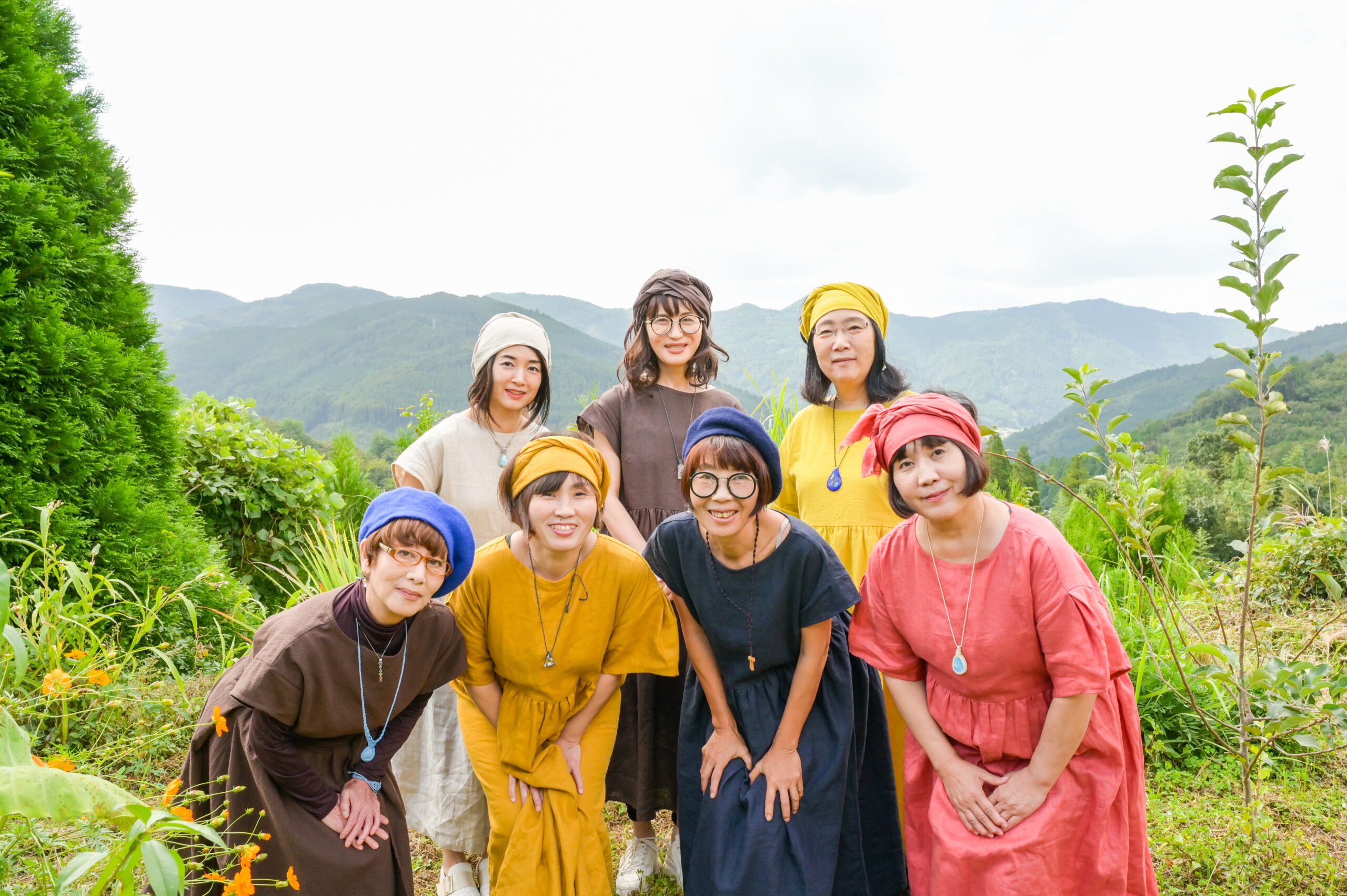 陽だまり笑堂のメンバーが山の風景の中で笑顔で集まっている写真。皆さまの人生に喜びをもたらすことをミッションとするチーム。